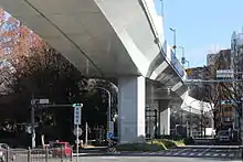 高速2号（画像左）と高速分岐2号（画像右）。同じ都心環状線を構成するも都市景観の配慮から外観が大きく異なる。画像左の橋脚はスペースデザイナーの提案によってグレーに塗装されている。画像右側の高速分岐2号は都市景観の配慮からオフホワイトで統一された。