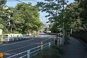 市道と閑静な住宅街の直下にトンネルを建設した。右は名古屋大学で西行きトンネル近傍に位置する。（千種区東山元町）