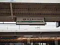 駅名標と1番ホーム屋根に吊るした干し柿(2015年11月)