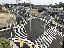 交差点を高台から撮影、左奥方が2021年開通区間（2021年4月）