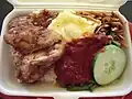 弁当として売られる、鶏肉を付け合わせたナシルマッ