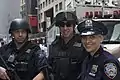 警察官達。左と中のESU(特殊部隊)隊員は、ヘルメットや特殊部隊用出動服を装着している。右の女性警察官は夏用勤務服で、被っている帽子は制式の八角帽 (8 point hat)。また襟章と名札から、ミッドタウンサウス分署所属のヴィッカース巡査と分かる。