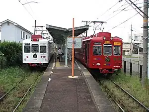 日前宮駅で並ぶいちご電車(左)とおもちゃ電車(右)