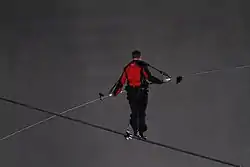 A man in black and red on a tightrope