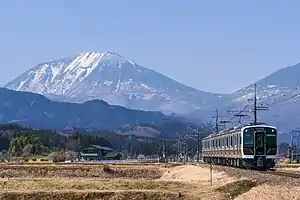 男体山をバックに走行するE131系電車(2022年3月 日光駅 - 今市駅間)