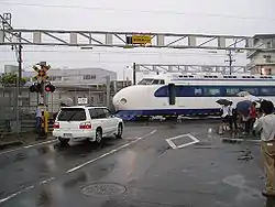 フル規格新幹線車両の通過する踏切（浜松工場入出庫線）。