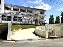 陽明小学校北門歩行者用階段と自動車用スロープがある。奥の建物は北校舎。