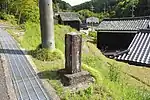 村積神社標柱の近くにある道標。「右ゑたみち　左花園山村積大明神　嘉永六年」とある（2022年（令和4年）4月）