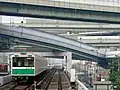 大阪港駅付近を走行する20系電車。上は阪神高速道路の天保山ジャンクション。（2006年6月28日）