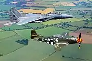 F-15Dと並んでイギリスの農業地帯上空を飛行するD型。F-15の後席乗員バド・アンダーソンはかつてP-51のパイロットだった(2001年7月)