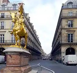 パレ・ロワイヤル側起点のピラミッド広場から見る(オペラ大通り方向の)ピラミッド通りとジャンヌ・ダルク像 (Rue des Pyramides vue de la place des Pyramides ; au premier plan, la statue de Jeanne d'Arc).