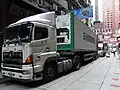 香港の繁華街で、背高40 ftコンテナから商品を配達している風景。狭い国土ながら繁華街でも、2階建てのバスや電車が走り回っているので、日本のように高さ制限で、通行ルートが制限される事も無い。