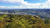 Looking westward towards central Whangārei from the Mount Parihaka lookout, with Te Matau A Pohe bridge and the suburb of Port Whangārei to the far left, the Discovery Settlers Hotel in the suburb of Regent to the far right, as well as Maungatapere and Te Tangihua in the background.