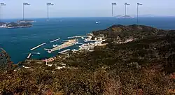 菅島の大山から望む菅島漁港、遠景は左から答志島、大築海島、小築海島、神島、その左奥に渥美半島の伊良湖岬