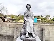 横溝正史像庭に設置されている。像は疎開宅での写真を基に作られている。