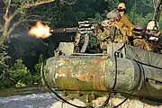 舟艇に搭載したMk 25 Mod 0で実弾演習を行うアメリカ海軍特殊部隊の兵士銃本体の手前に空薬莢、向こう側に分離したリンクが排出されている。また射手が保持する操作ユニットには電源ケーブルが接続されている