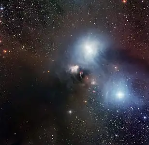 チリ アタカマ砂漠にあるヨーロッパ南天天文台ラ・シヤ天文台のMPG/ESO 2.2m望遠鏡の広視野イメージャ (Wide Field Imager, WFI) によって撮影された散光星雲NGC 6729(中央)と周辺の星雲。この画像は、赤・緑・青それぞれのフィルターを通して撮影された12枚の写真を組み合わせて製作された。