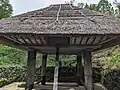 沖永良部島の高床倉庫。四本柱の上部に鉄板を巻いてネズミの侵入を防ぐ。(川崎市多摩区の日本民家園)