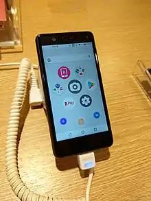 店頭に展示された本体色ナイトブラックのRakuten Miniのホーム画面が表示されている画面側を写した写真