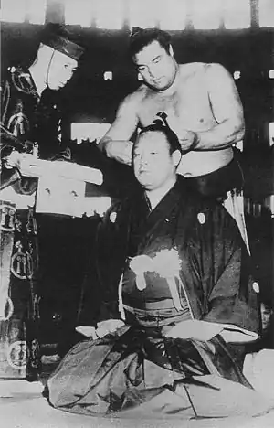 双葉山の断髪式。鋏を入れる羽黒山（1946年11月19日）。