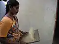 箕を使って米をより分ける、南インドのタミル人女性/2011年撮影。