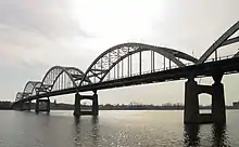 An arch bridge, with 5 arches sits over a river