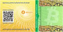 開封明示シールが貼られ、秘密鍵が隠されているビットコインペーパーウォレット（bitcoinpaperwallet.comによって作成）