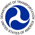 アメリカ合衆国運輸省の印章。白い三脚巴 (triskelion)が主体で、青色は背景