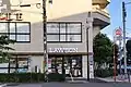 ローソン成城学園前駅西口店（茶帯に白文字の外観）