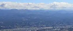 西側の風越山から望む天竜川の左岸の飯田市下久堅地区周辺、遠景は伊那山地