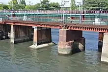 神崎川に架かる新神崎川橋梁には、東海道本線時代の橋脚が一部流用されていた。円柱形の橋脚がそれである。
この新神崎川橋梁は、淡路駅付近立体交差事業に伴い、2017年に仮線（左写真奥）に切り替えられている。
