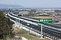 菰野市街を通過。奥に菰野ICを望む。起点から暫くは平野部を通行。