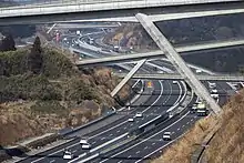 画像左 : 静岡県富士市内。往復6車線を前提に着工され、その後2003年の第1回国幹会議の決定で暫定4車線で整備するように計画変更した経緯から6車線分の幅がありながら4車線に縮小された。画像右 : 御殿場JCTに近接する今里トンネル。左右のトンネルの離隔はわずか4 - 6&nbsp;m。土被りも少なく、地質も富士山噴火により流れ出た自立性の悪い自破砕溶岩層を含み、地盤改良なしでは掘削不可能であった。こうした悪条件下で片側2車線断面を3車線断面に拡幅することは困難であるため、当初から完成断面で掘削された。
