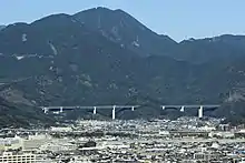 新清水JCT - 新静岡IC間に位置する猿田川橋と巴川橋。静岡市街から一望できる場所にあるこの橋は、竜爪山の麓に位置し、山岳地形に溶け込む橋梁形式が求められた。このことから、通常はコンクリートである箱桁側面を透過性のあるトラスに置き換えた。柱頭部はトラスのイメージでV字とした。