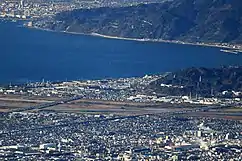 静岡市清水区由比地区付近。画像左 : 一番海寄りの道路が東名高速、中央が国道1号、山寄りが東海道本線。東名の当該区間は高潮により度々通行止めになる。また駿河湾沖を震源とする大地震が発生した場合は東名へのダメージが大きく、地滑りや津波の危険も存在する。画像右 : 富士川から奥の由比海岸を望む。海岸から5&nbsp;km以内には東海道新幹線も並走しており、日本の大動脈が自然災害にさらされやすい地域に密集している。