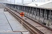 東北新幹線大宮駅構内に設置されている添線式軌道回路（前方）、手前にある標識は敷設箇所を示す停止限界標識。