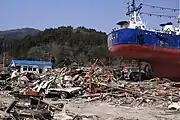 津波に襲われた鹿折唐桑駅(左奥)と大量の瓦礫。右には大型漁船が打ち揚げられている。