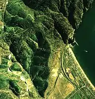 静狩峠の空中写真国土交通省 国土地理院 地図・空中写真閲覧サービスの空中写真を基に作成（1976年撮影）画像左の上部が静狩峠。噴火湾から至近距離にある事と、地名の由来となった砂浜（海岸線）の先に山が連なっている様子がわかる。