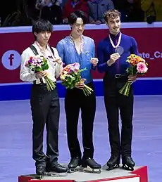 2023年スケートカナダの表彰式にて、2位の三浦佳生、3位のマッテオ・リッツォとともにメダルを掲げる山本草太の写真