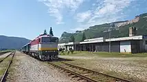 セメント原料の石灰石を産出するゴンバセク採石場を望むスラヴェツヤスキニャ鉄道駅に停車中の観光チャーター列車（2017年）