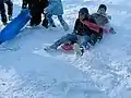 ソリで遊ぶ子供たち
