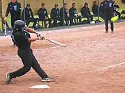 ソフトボールの打者(右打者。スイングしたバットがボールに当たり、打球が飛んでゆくところ)