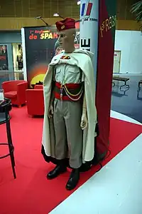現行のスパッヒの軍服。バーノスの下には通常の軍服を着用しており、赤いギャリソンキャップを被っている。