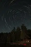 北半球では、天の北極の周りを周極星が回っているように見える。ポラリス(天の北極から 1° 以内)は、この写真の中央右にあるほぼ静止している明るい恒星である。