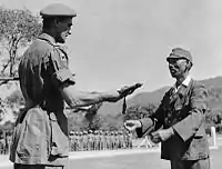 1945年10月、英印軍少将A・W・クローサーに対し、降伏の証として自身の軍刀(昭9制/昭13制刀)を手渡す陸軍中将河田槌太郎第31師団長