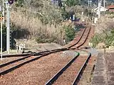 上りホームより東萩方を望む。線路の砂利の色が変化している部分が3番線への分岐跡(2021年2月)
