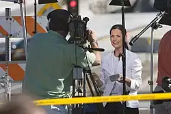 事故現場はTVクルーによって背景として活用された（ここではMSNBCのコンテッサ・ブルーワーが伝えている様子）。