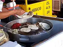 牛肉を炒めたスアデーロを使ったタコスを準備するタコスタンド（メキシコ）