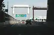 東行き道路から右の西行き料金所を見る。東行きも名二環に直通の場合はこの先の料金所を通る。