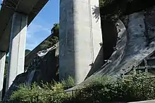 竹割り型土留め工法。地形改変面積を縮小することで森林伐採範囲を縮小して環境負荷の低減を図っている。画像左 : 芝川高架橋の竹割り型土留め工法。この地の平均斜度は45度。従来の工法では山肌を大きく削り取ることになり、自然のバランスを大きく損なうところであった。画像右 : 宍原第一高架橋の同工法。
